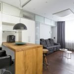 Mobilier alb și masă din lemn într-un apartament studio